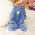A dog wearing a blue four-legged plush jacket with a high collar and a tow ring on the back.