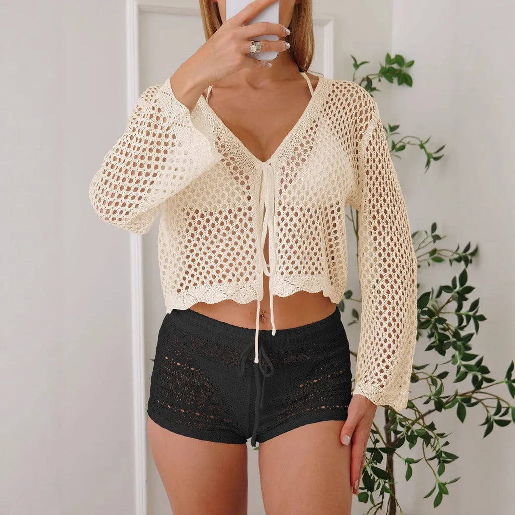 Women's apricot bell sleeve hollow knit cardigan blouse on a hanger.