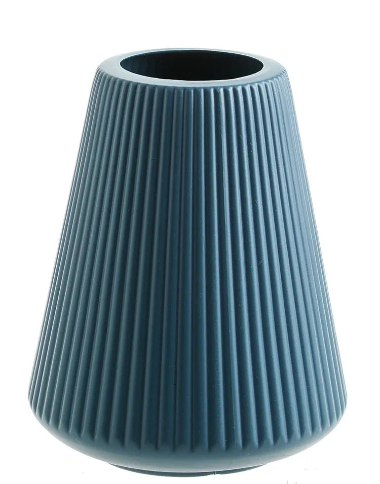 Melamine plastic flower vase in blue colour on desktop with white flowers