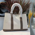 Women's canvas and leather crossbody tote bag in bucket shape with soft handles and internal zip compartments
