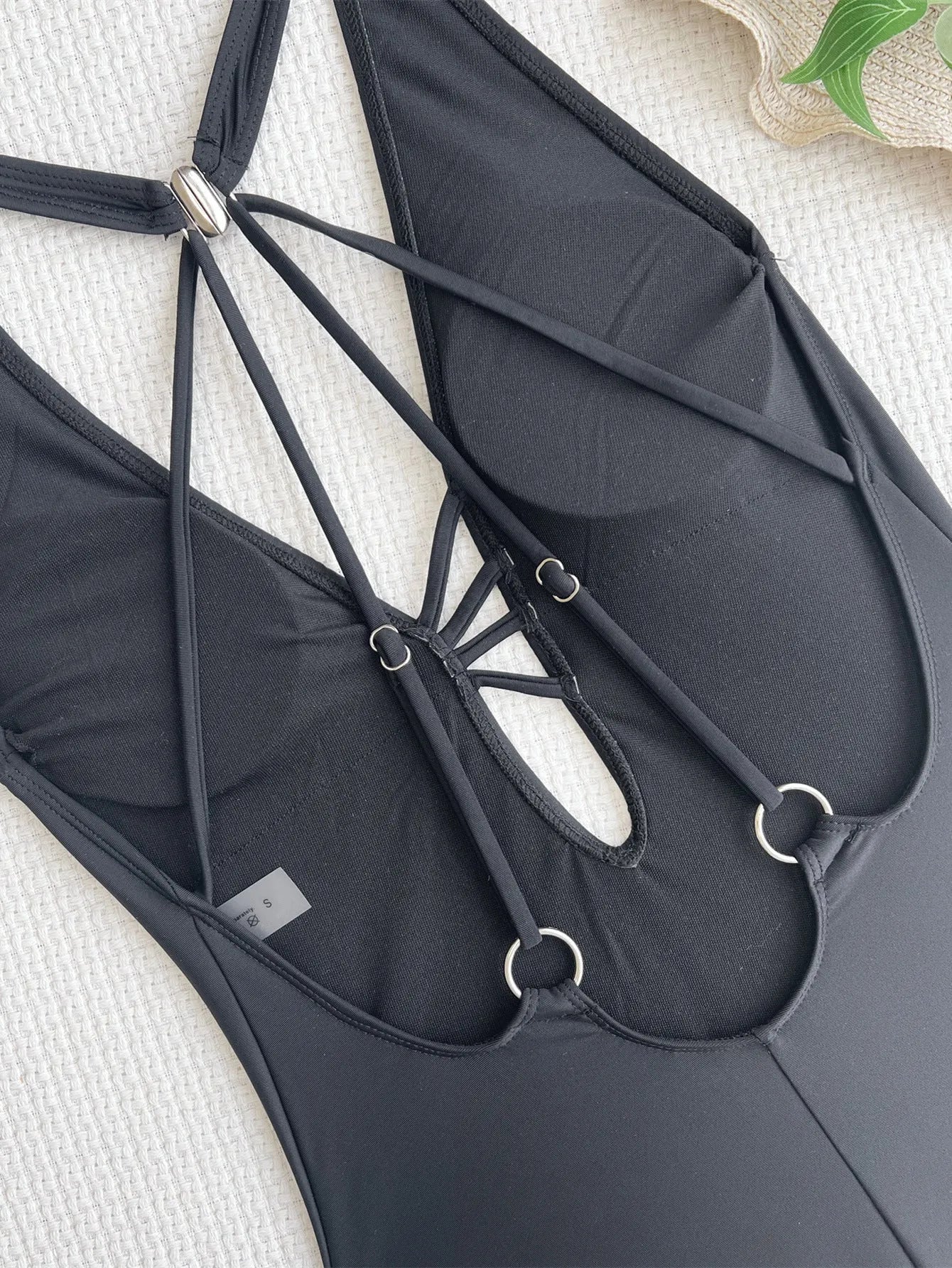 Black women's one-piece nylon bikini swimsuit on a mannequin, showing solid colour design.