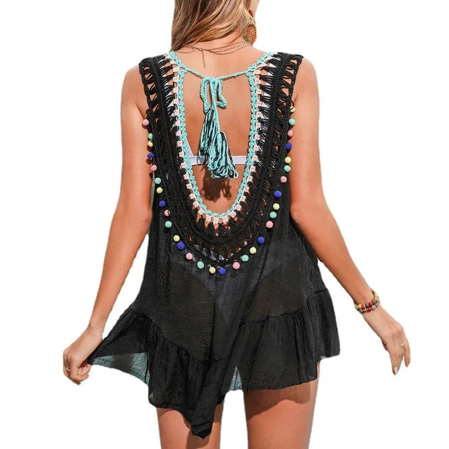 Black hand-crocheted women's beach cover-up vest with ruffles and cut-out design on a mannequin.