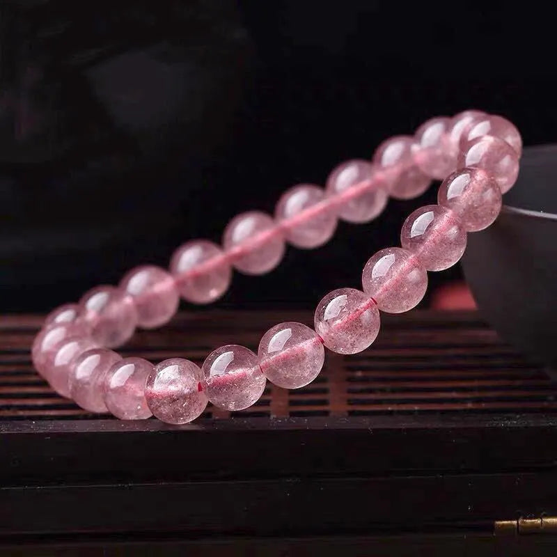 Women's strawberry quartz crystal bracelet with polished beads, showing size options of 6mm, 8mm, and 10mm.