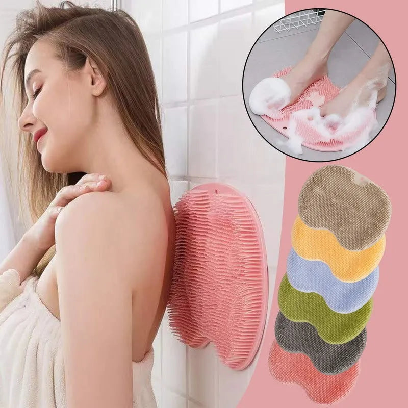 Orange silicone bath massage brush mat with suction cups on a bathroom floor