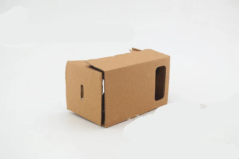 Pink and white cardboard VR headset for smartphones with adjustable strap and magnetic button.