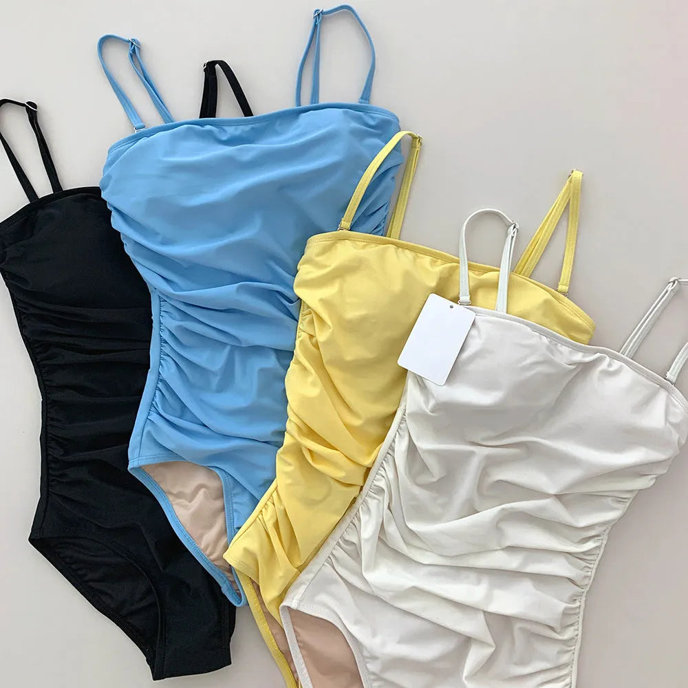 Sling style belly pleated one-piece swimsuit in blue, white, yellow, or black colours