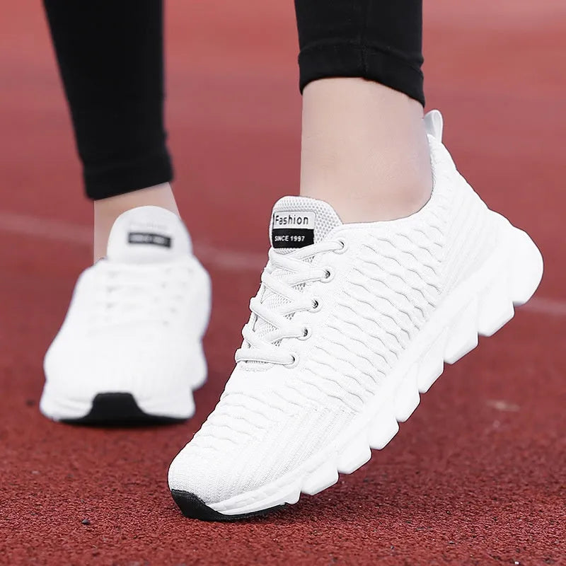 Women's running shoes in black, pink and white colours showing fly weave upper and durable outsole