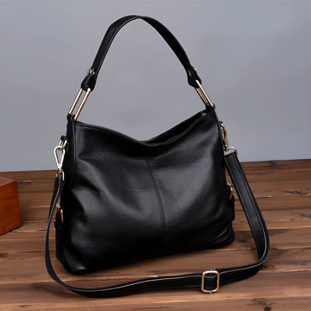 Genuine leather women's crossbody bag in square vertical design, showing internal zipped phone and document pockets.