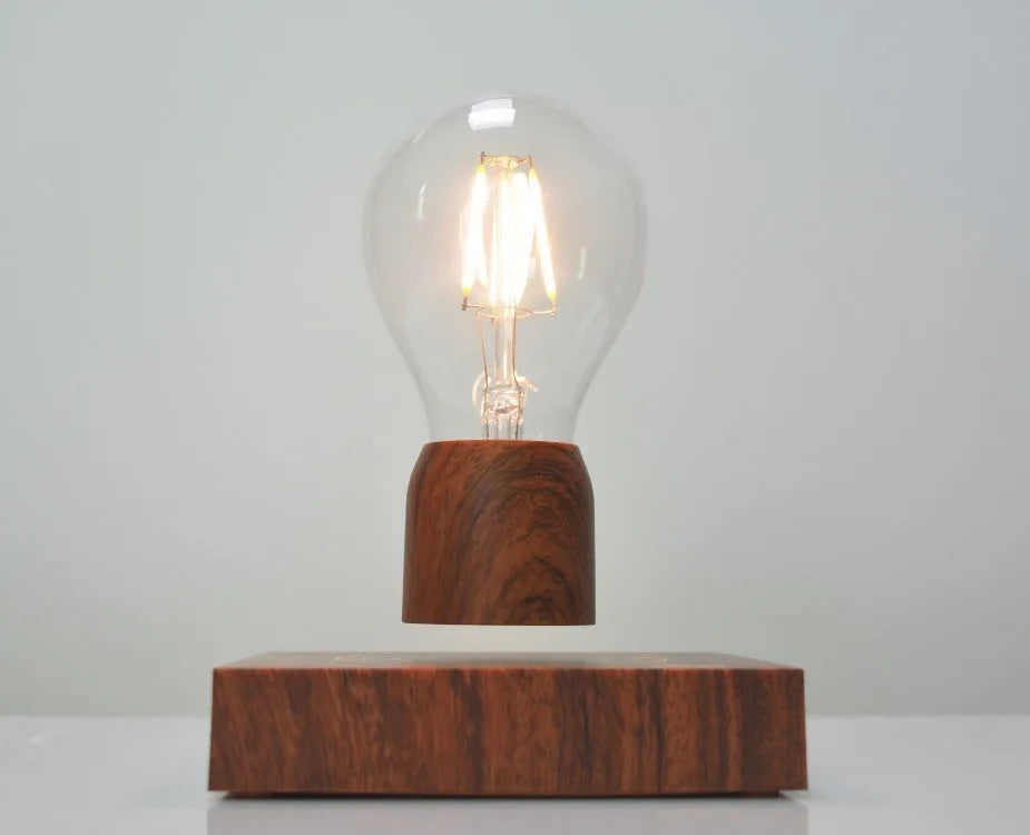 Magnetic levitation floating light bulb with UK plug on imitation wood base.