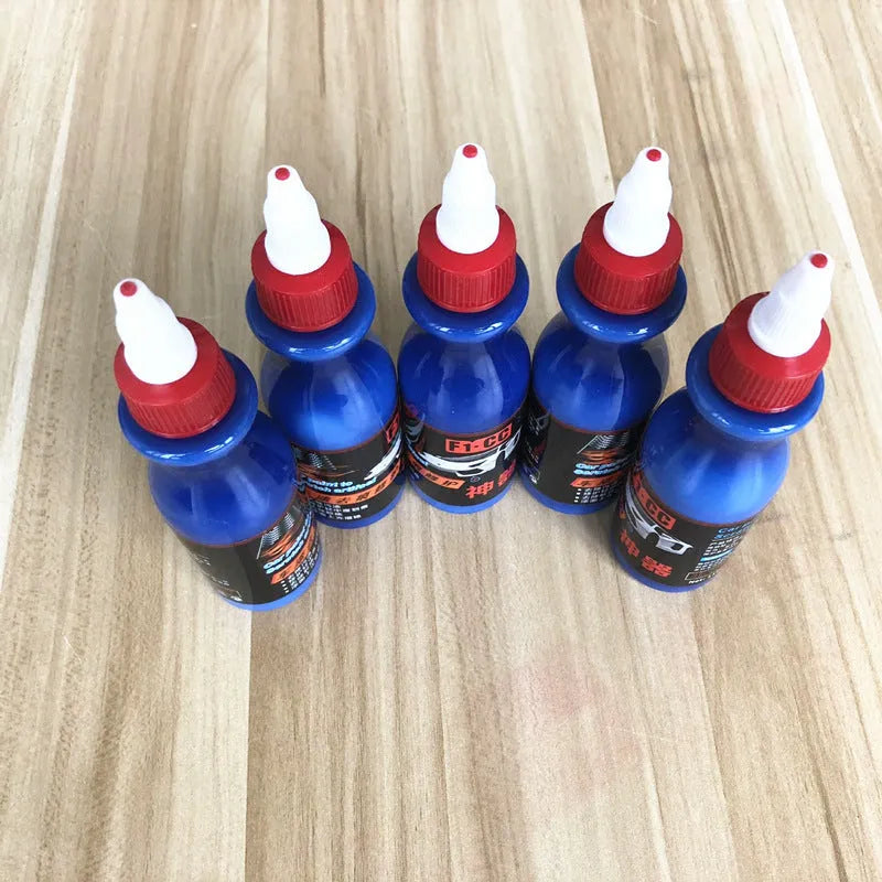 Small blue container of scratch repair agent with integrated wiping tool for automotive paint