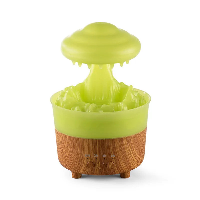 Wood grain green rain cloud shaped humidifier diffuser with coloured LED light on a table.