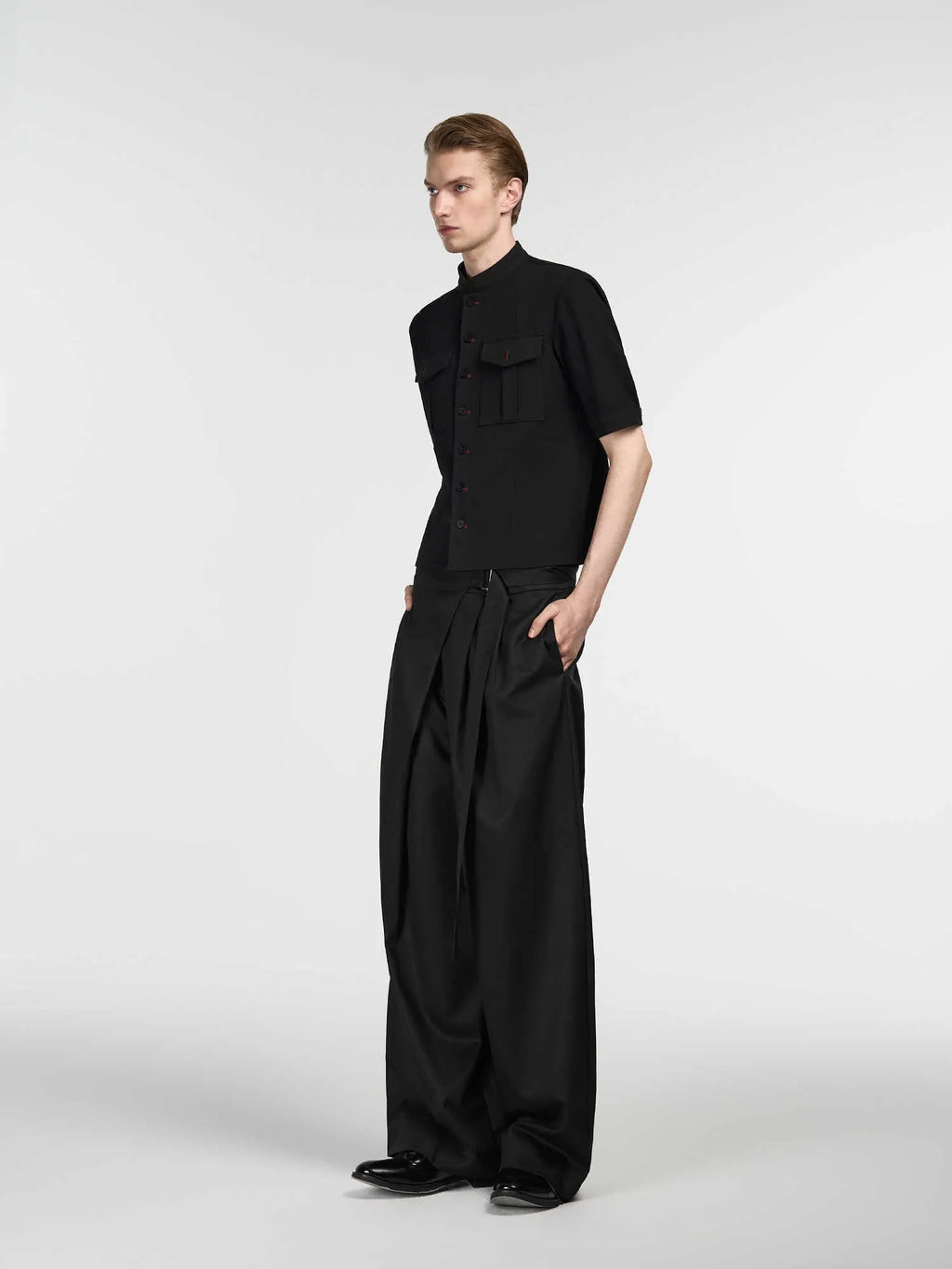 Black loose fit straight-leg trousers with adjustable waistband and single pleat detail