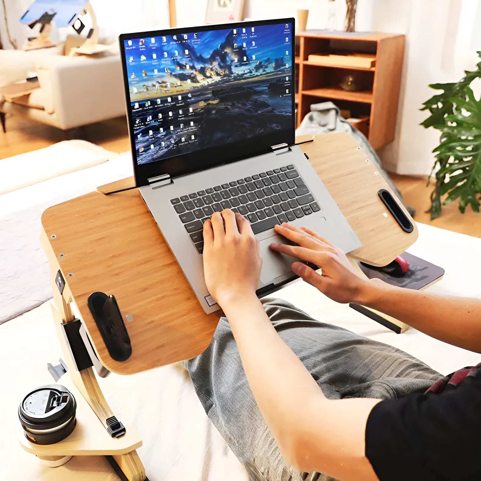 White wooden folding laptop desk with adjustable angle, shown open on a bed.