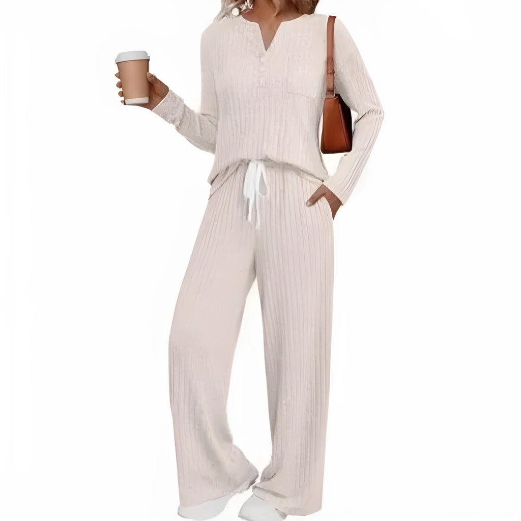 A person wearing a striped V-neck knit long coat with lace-up details and pockets, paired with matching pants.