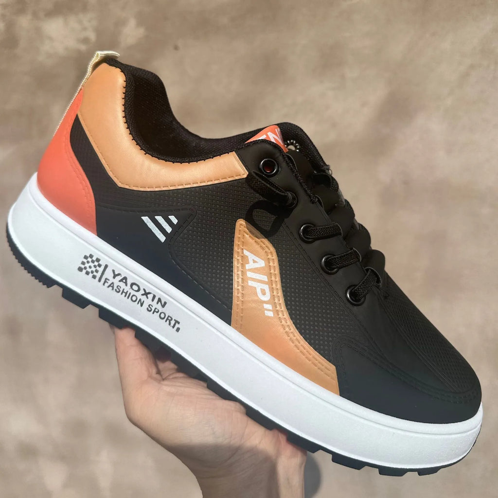 Men's white casual trainers with orange, black, or brown accents and round toe.