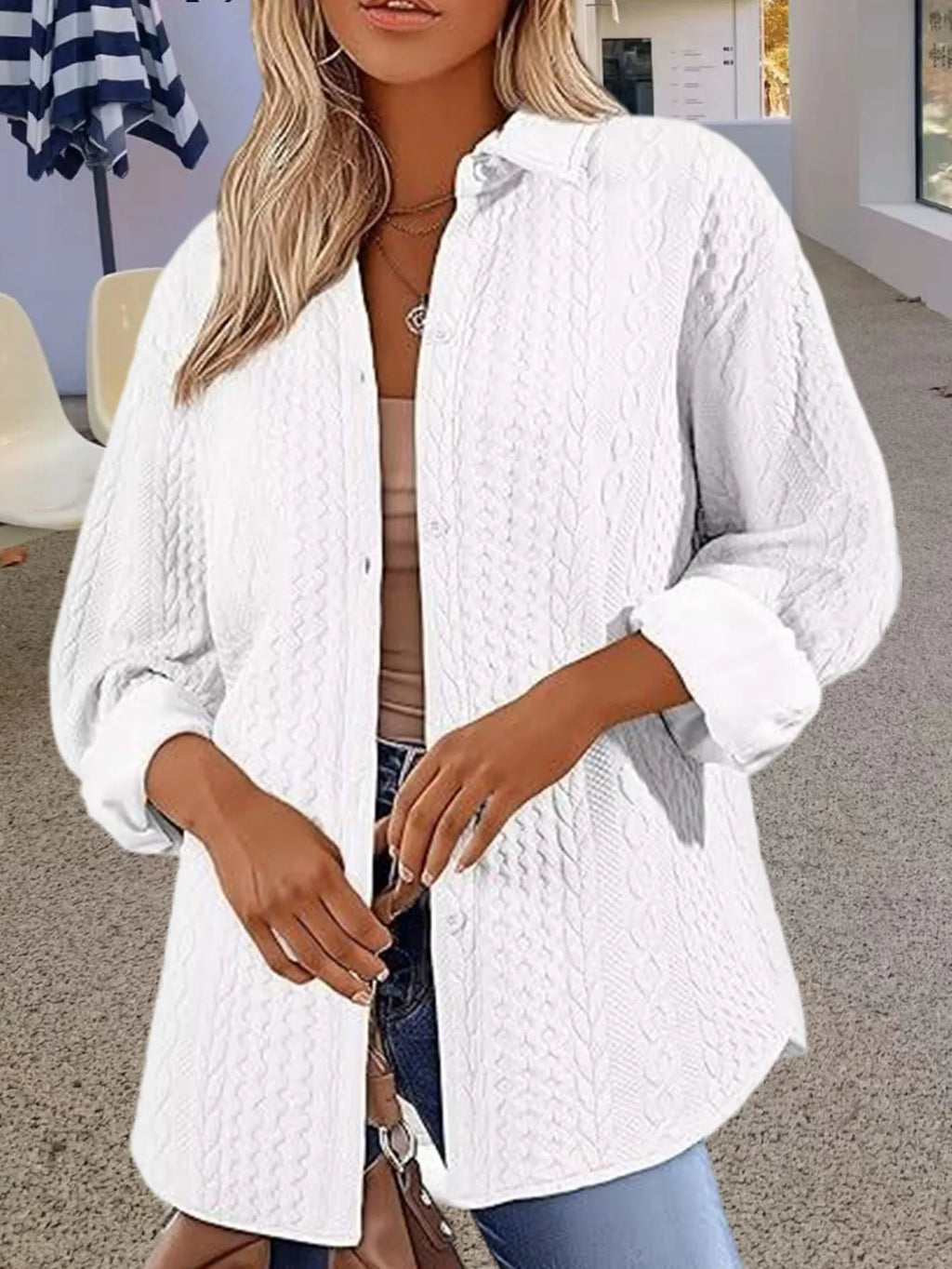 Women's solid colour long-sleeved knitted cardigan in black on a hanger, showing cardigan style and texture.
