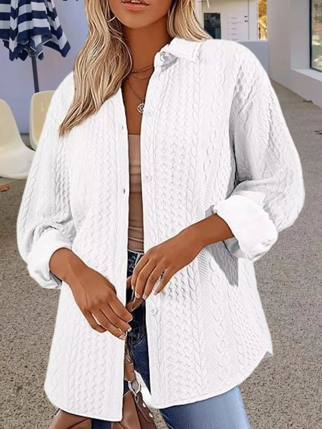 Women's solid colour long-sleeved knitted cardigan in black on a hanger, showing cardigan style and texture.