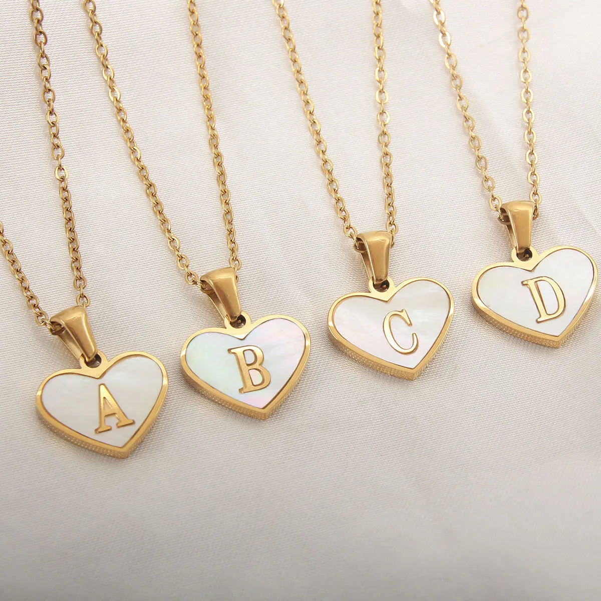 Gold plated heart-shaped white shell pendant personalised initial necklace on a stainless steel chain.