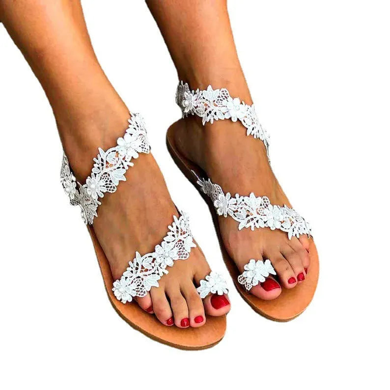 White women's flat sandals with rhinestone flower decoration on patent leather upper