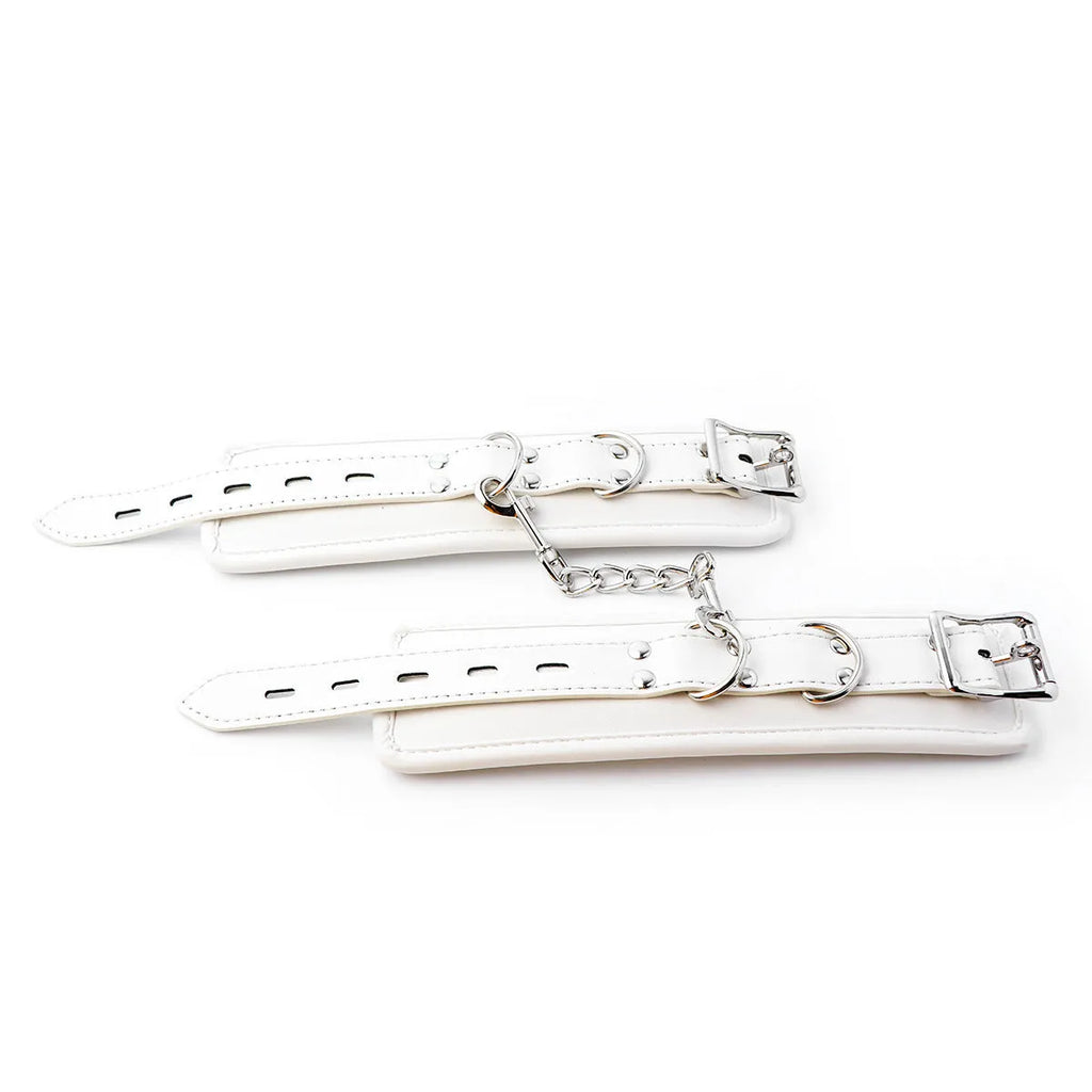 White PU sponge bondage set showing handcuffs, footcuffs, and a neck scarf laid out.