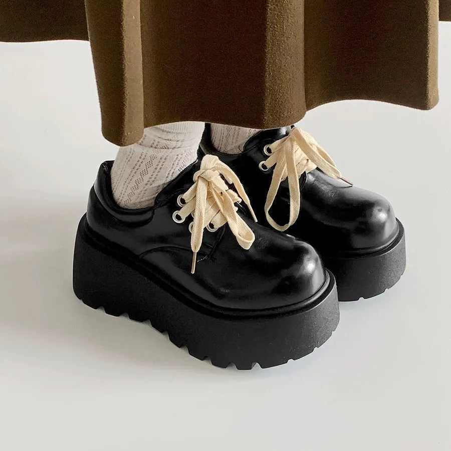 Women's matte black lace-up ankle boots with a thick rubber sole and a chunky heel on a white background.
