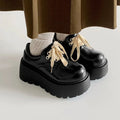 Women's matte black lace-up ankle boots with a thick rubber sole and a chunky heel on a white background.