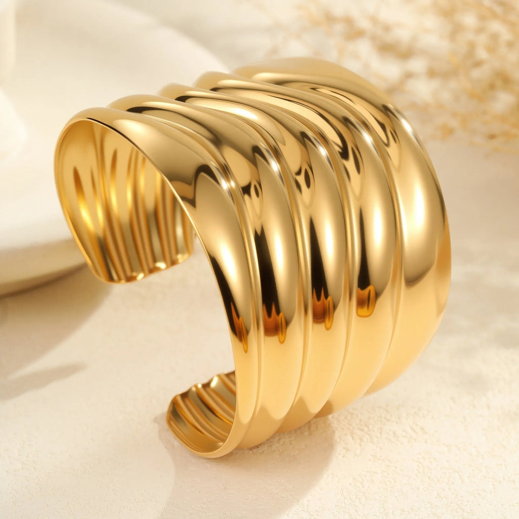 Women's exaggerated wide stainless steel bracelet with geometric wave design and niche opening in gold finish