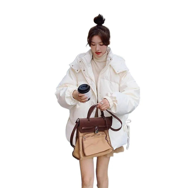 Women's loose black padded winter jacket with princess sleeves on a hanger.