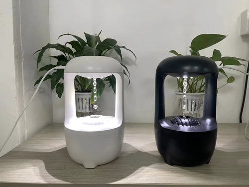 Black anti-gravity humidifier showing water droplet backflow effect with USB cable