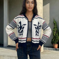White women's zip-front cardigan with lapel collar and contrast-colour jacquard stripe pattern.