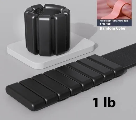 Adjustable black silicone fitness weight bracelet with Velcro strap shown on a wrist.