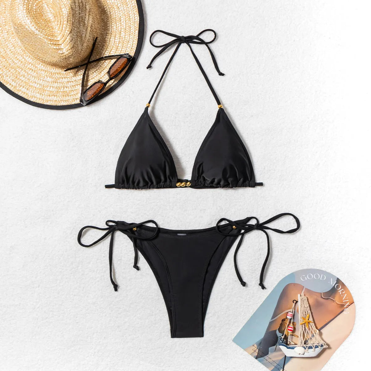 Black women's bikini swimsuit with metal bead split design on a mannequin.