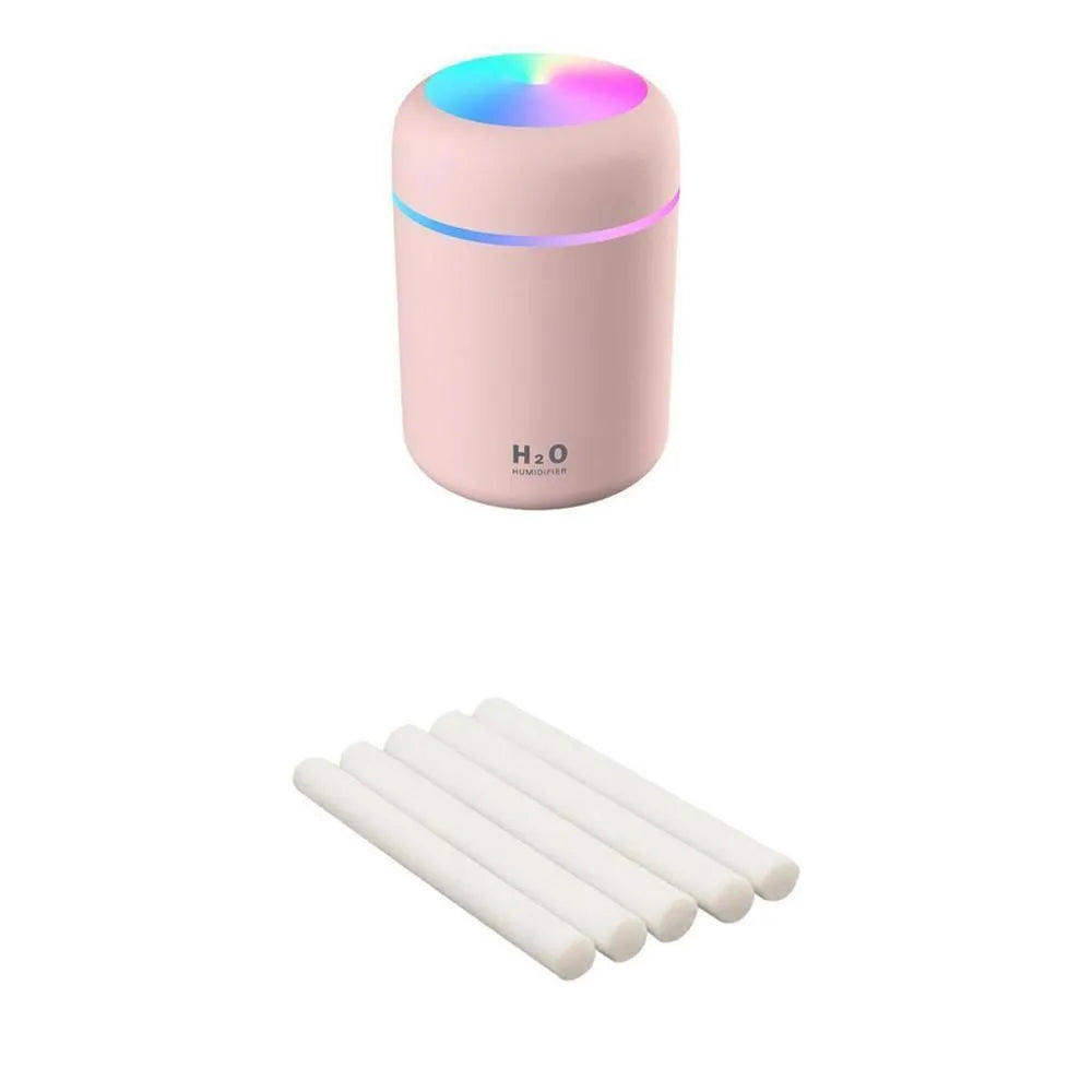 Pink USB desktop humidifier with coloured lights and water tank on a wooden desk