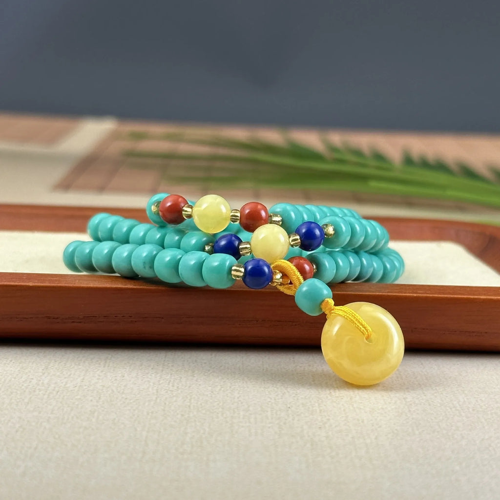 Turquoise lucky pendant necklace with hand-woven mesh flower design on ball bead chain