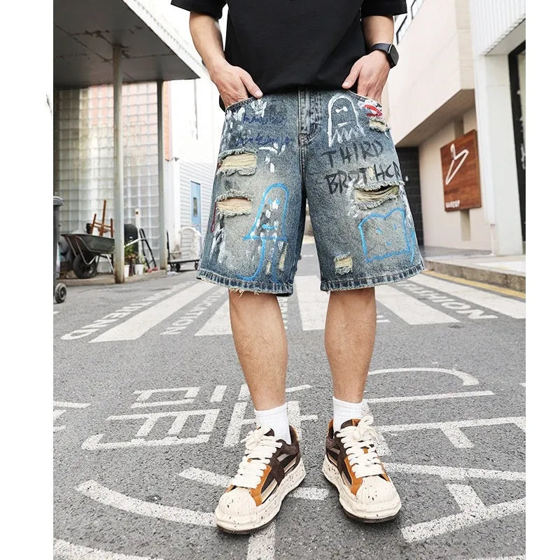 Blue ripped men's denim shorts with graffiti detail and a straight leg.
