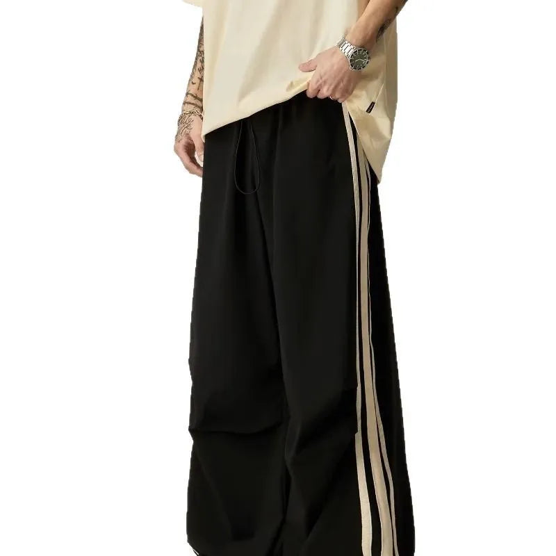 A man wearing black high-waisted wide-leg straight-cut casual climbing trousers.