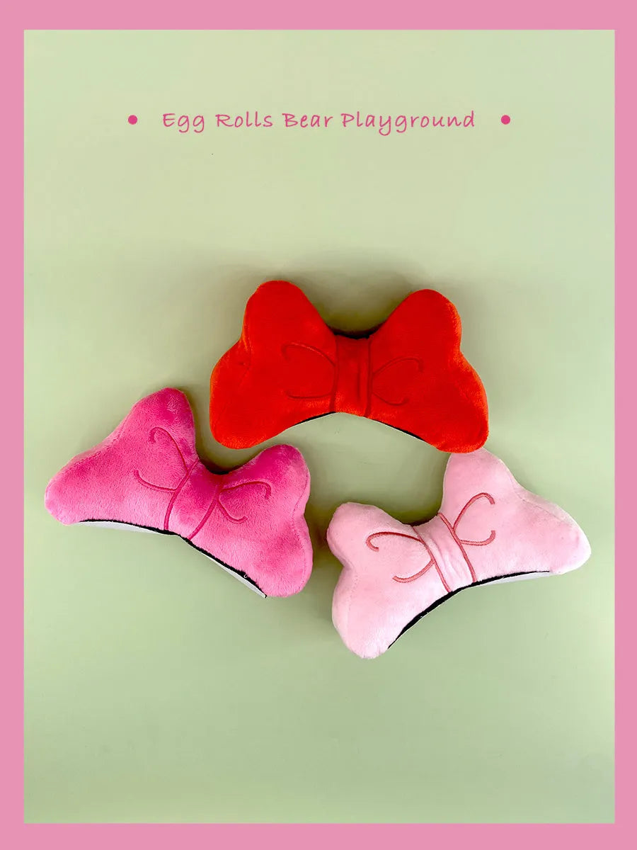 Soft plush bow tie helmet decoration for electric motorcycle and ski helmets in red, peach pink, and rose pink.