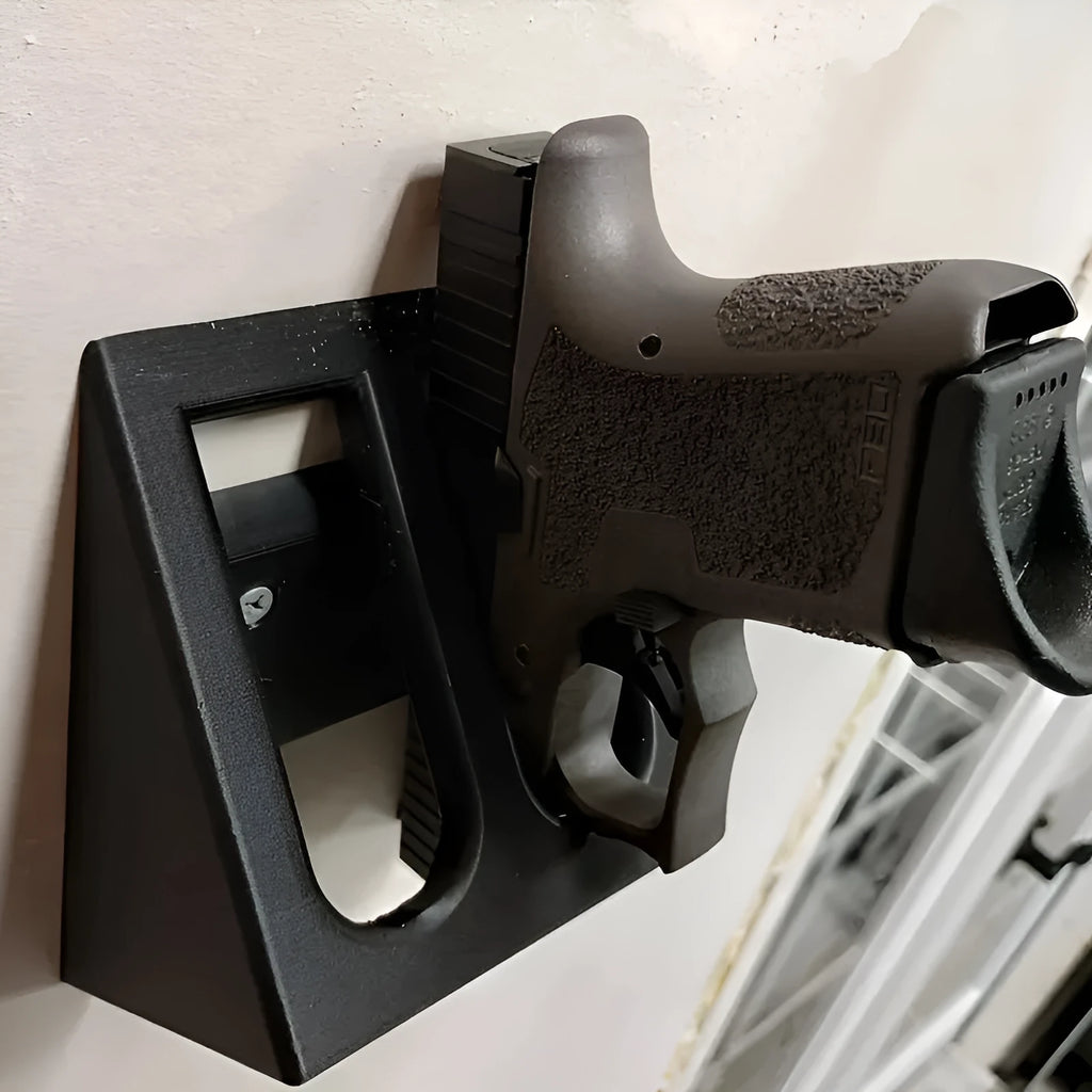 Black plastic punk-style pistol display stand for airsoft guns, measuring 10.85 by 7.6 cm.