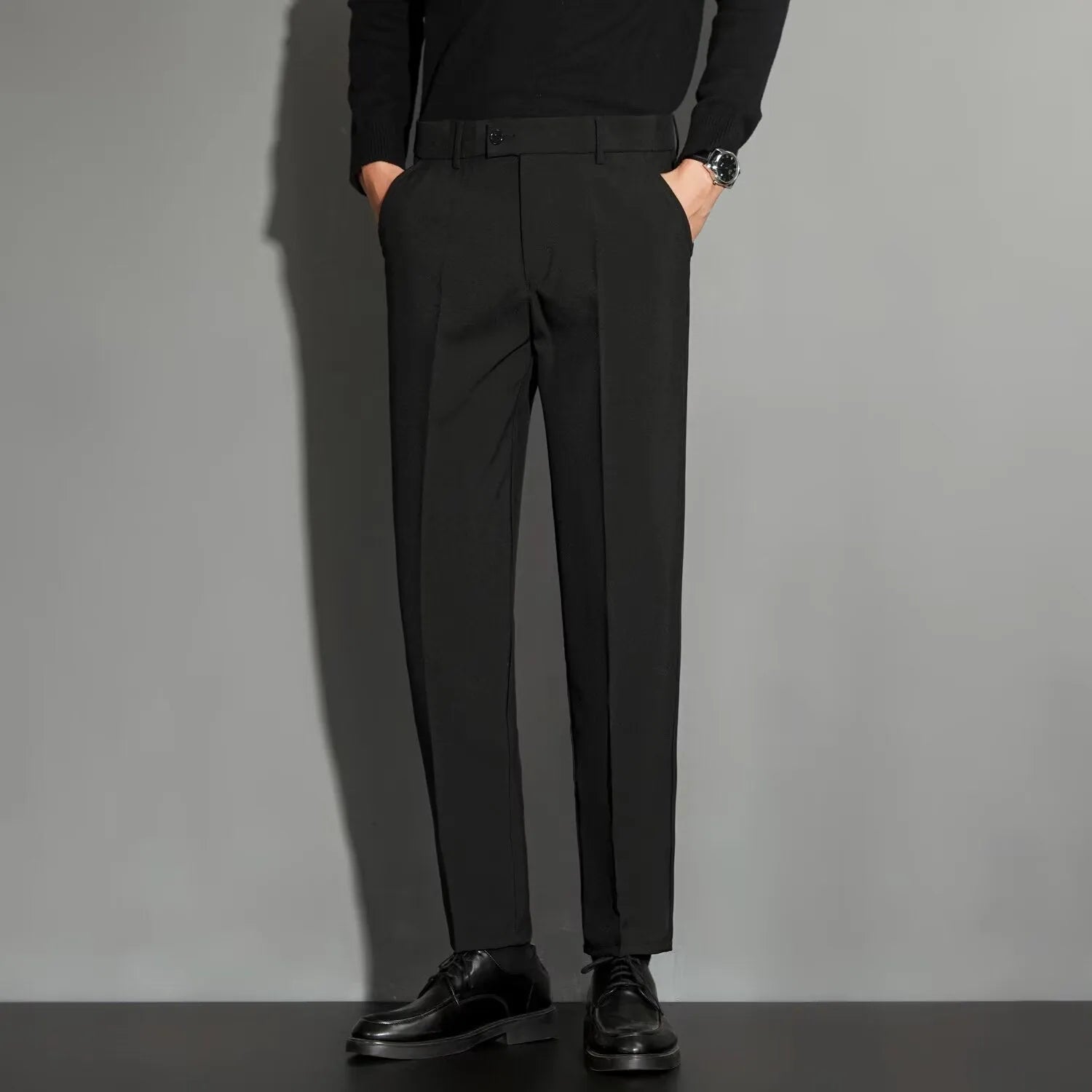 Man wearing straight-leg suit trousers with an ankle-length draping effect in a light colour.