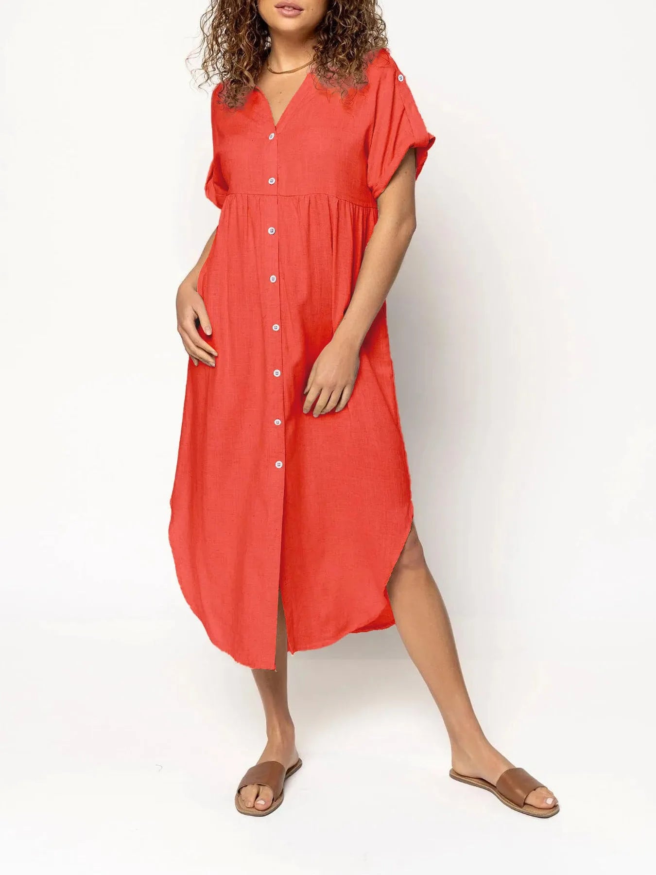 A loose-fitting, solid colour mid-length casual dress with a button-down front and regular sleeves.