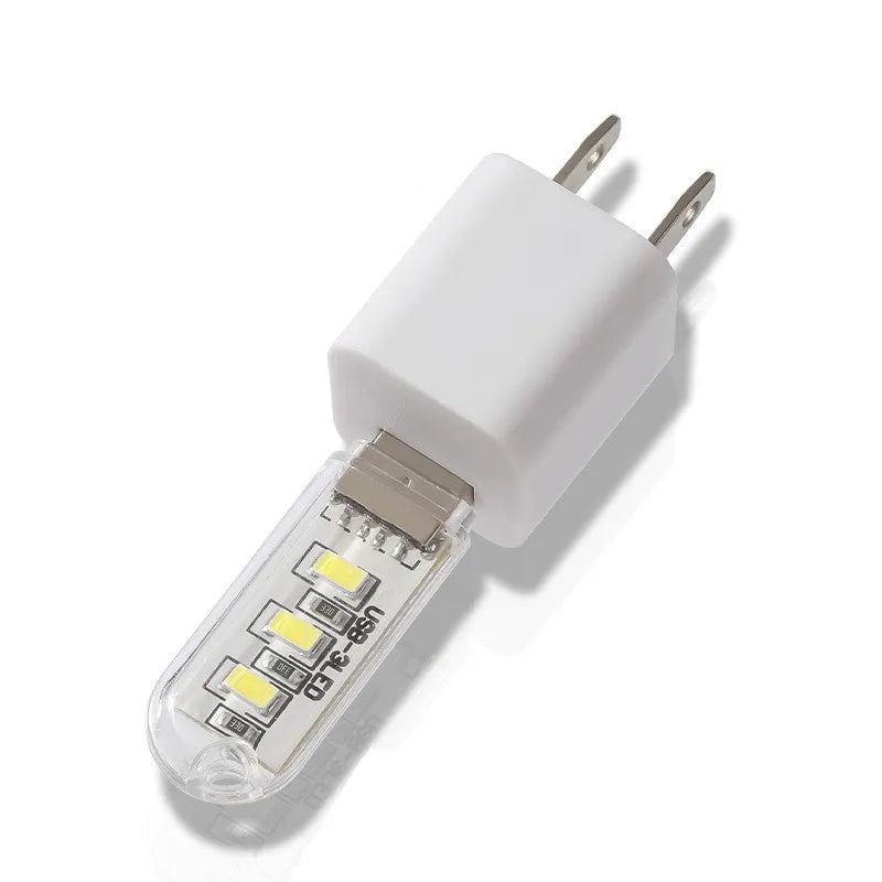 Small cylindrical USB baby night light showing warm yellow glow on a dark background.