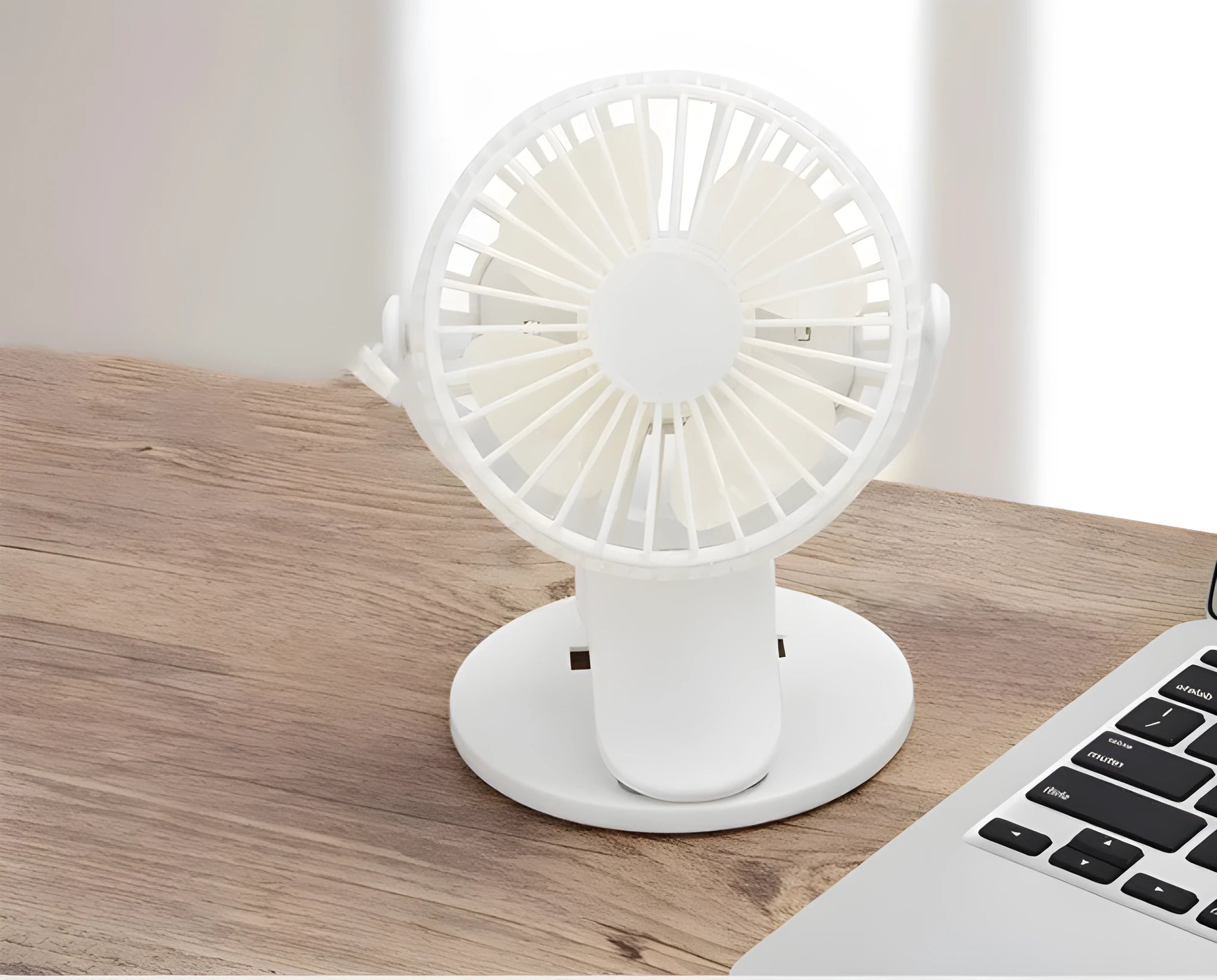 White USB rechargeable mini clip fan with plastic blades attached to a stroller handle.