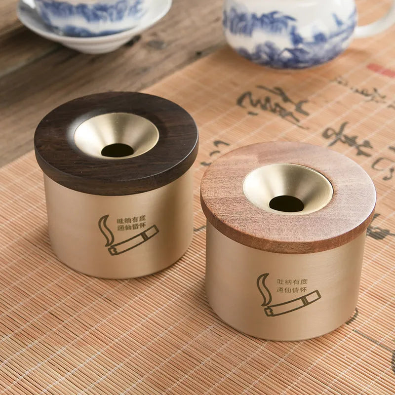 Brass ashtray with a wooden lid featuring a central hole, shown in black wood and red wood options.
