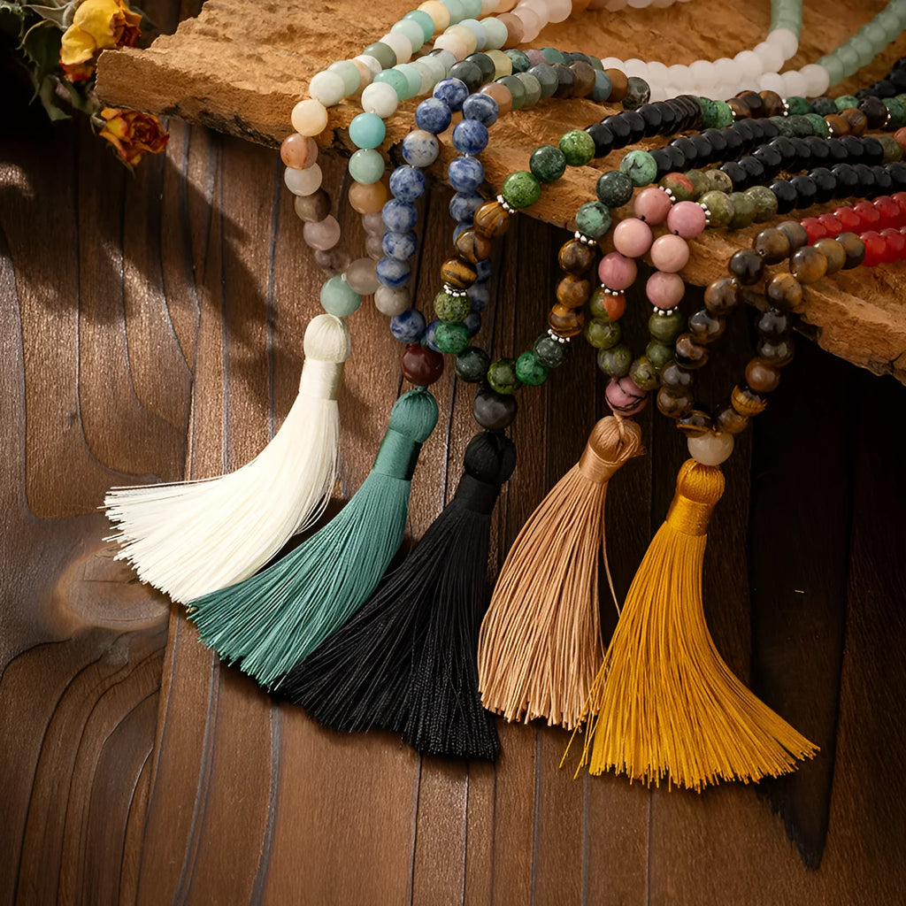Long natural stone beaded sweater chain necklace and matching bracelet in bohemian style on a grey background.