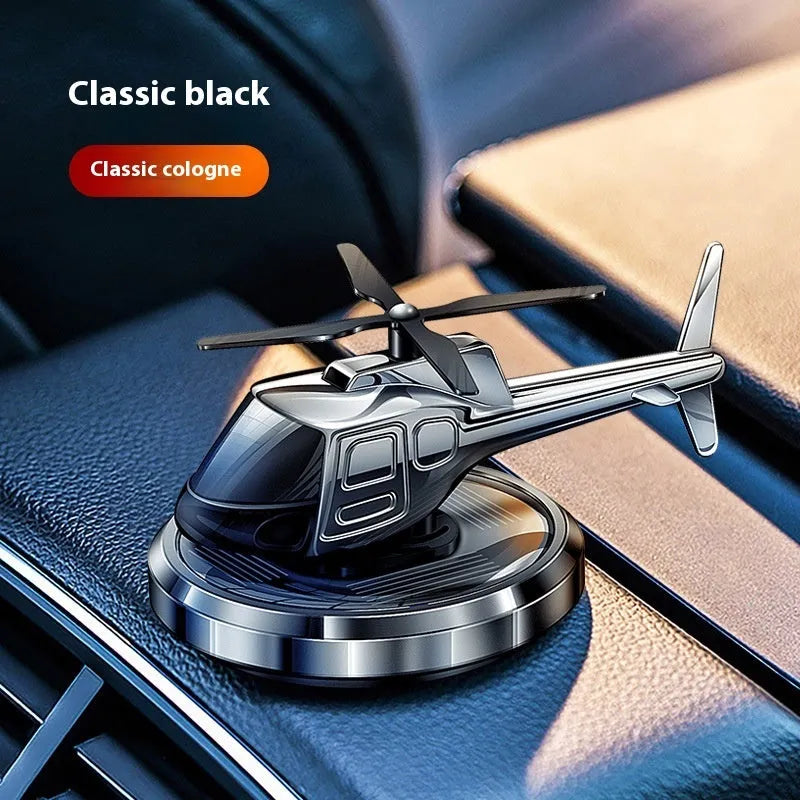 Silver metal helicopter car air freshener with rotating blades on dashboard