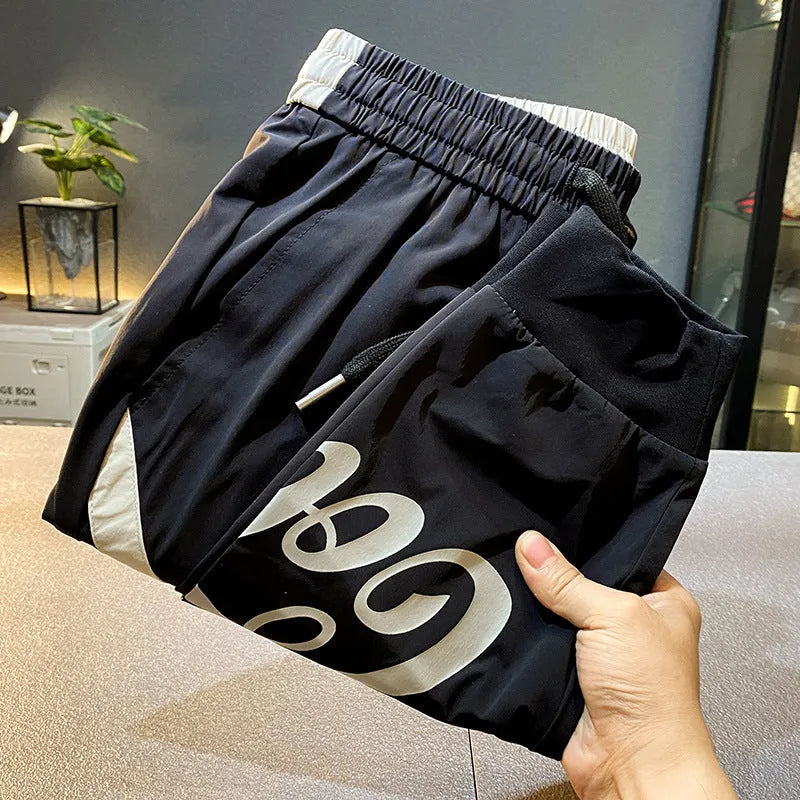 Men's black cropped trousers with ankle banding in ultra-thin ice silk fabric laid flat to show casual design.