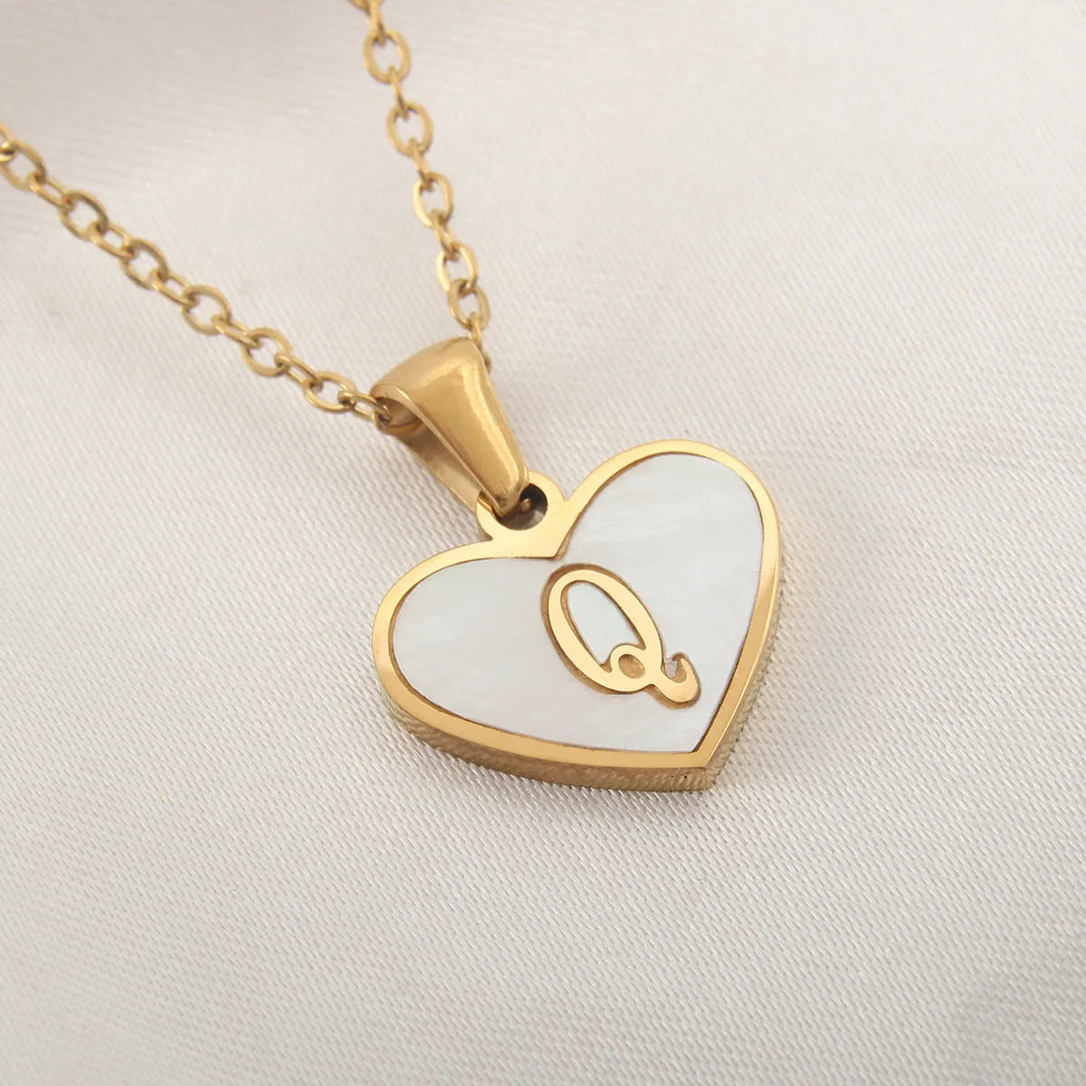 Gold plated heart-shaped white shell pendant personalised initial necklace on a stainless steel chain.