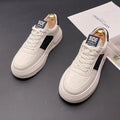 White and green sports casual shoes with cloth upper and rubber foam sole on a plain background.