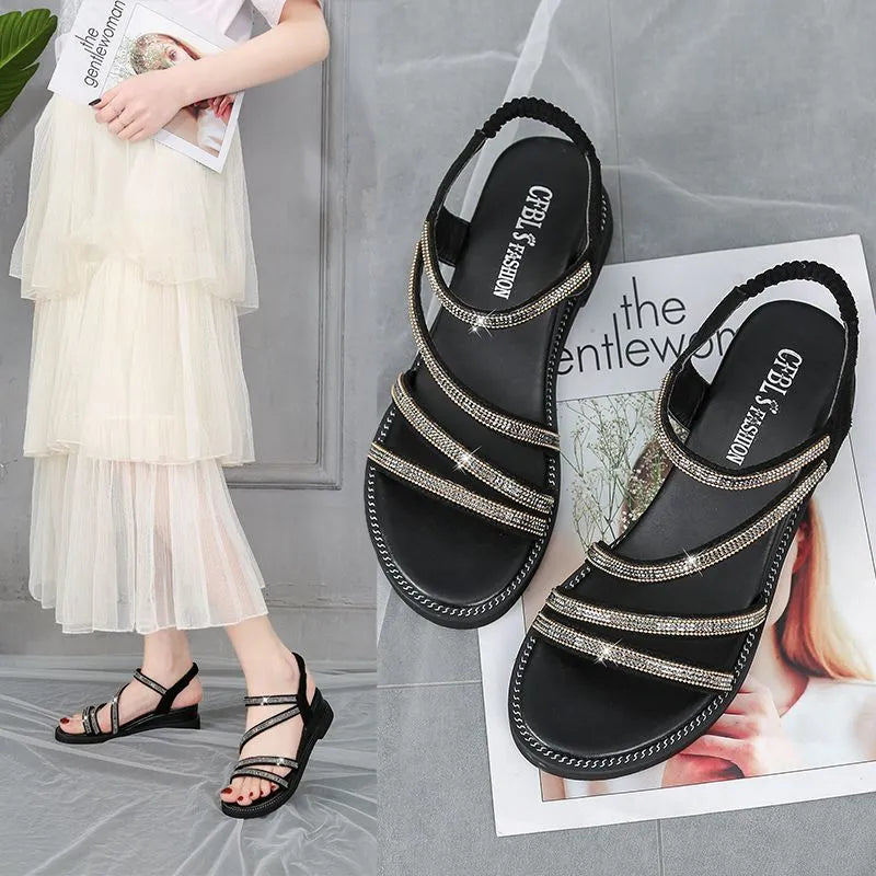 Women's silver flat sandals with elastic band and rhinestone sequin detail on a round toe.