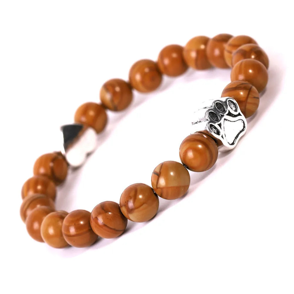 A round beaded stone bracelet in a Tiger Eye or Indian Agate style on a wrist.
